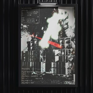 May include: A framed monochrome abstract print with a computer-generated design. The print features text and graphic elements, with a bright white and red burst of light. The frame is black, and the background is a black, vertically-lined wall.