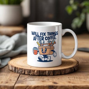 May include: White ceramic coffee mug with a cartoon illustration of a toolbox holding a cup of coffee and the text "Will fix things after coffee."