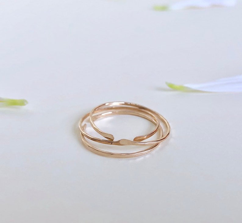Puede incluir: Tres anillos apilables de color dorado. Los anillos son finos y delicados, con una textura martillada.