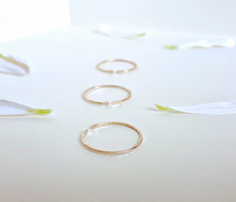 Puede incluir: Tres anillos de oro con acabado martillado. Los anillos est&aacute;n abiertos y tienen un espacio en un lado.