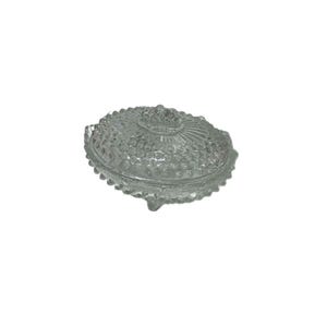 May include: Clear glass oval-shaped trinket dish with a textured, bubble-like pattern. The lid features a central floral design and the dish rests on three small feet. A decorative storage container.