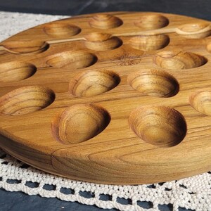 May include: A wooden serving tray with 18 individual indentations, perfect for serving appetizers or snacks.