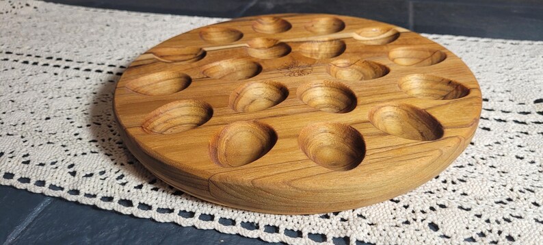 May include: A wooden serving tray with 18 individual indentations, perfect for serving appetizers or snacks.