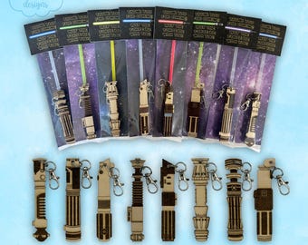 May include: Lightsaber keychain glowstick party favors. The wooden keychains have silver clasps. The glowsticks are in different colours. The packaging includes the text "Thank you for coming. May the force be with you!"