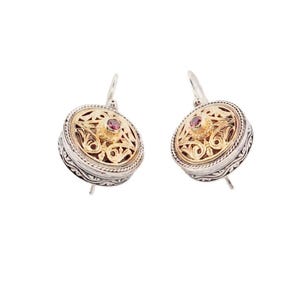 Peut inclure: Une paire de boucles d'oreilles en or et argent avec un motif de filigrane. Chaque boucle d'oreille comporte une petite pierre précieuse rouge et ronde au centre. Les boucles d'oreilles ont une fermeture à crochet.