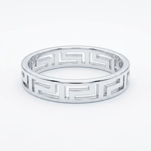 Può includere: Un anello d'argento con un motivo geometrico ripetuto. Il design dell'anello presenta un motivo continuo, traforato e a forma di labirinto, creando un look moderno ed elegante. L'anello è mostrato su uno sfondo bianco.