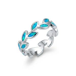May include: A silver ring with a leaf design. The leaves are filled with blue opal stones. The ring is set against a white background.