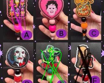 May include: Six badge reels featuring horror movie characters. A shows multiple figures, B a heart-shaped Leatherface, C a pumpkin-themed character, D the Jigsaw puppet, E Frankenstein's monster, and F a bald character holding a book.