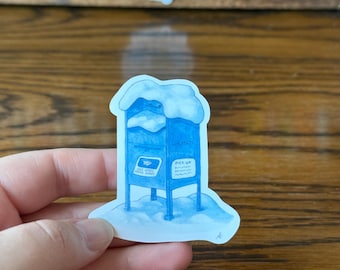 May include: A blue sticker of a mailbox covered in snow. The mailbox has the words "MAIL MATE" and "PICK UP" on it. A second sticker with a globe and heart design is in the background.