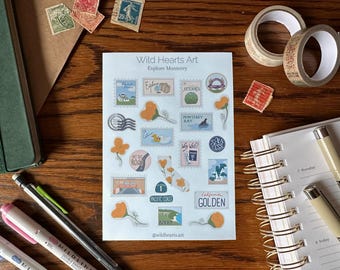 May include: A sheet of stickers featuring illustrations of California landmarks and scenery. The stickers are in a vintage style and feature a blue and white color scheme. The text on the stickers includes "Wild Hearts Art", "Explore Monterey", "Monterey Bay", "Pacific Coast", "California Golden", and "Say Yes".