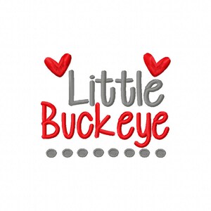 May include: Gray and red embroidered design with the text "Little Buckeye" and two red hearts. The design is surrounded by a row of gray dots.