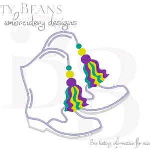 Op de afbeelding: Illustratie van een paar cowboylaarzen met hangende kwastjes. De laarzen zijn omlijnd in een lichtpaarse kleur. De kwastjes zijn paars, geel, teal en groen. De tekst "Bitty Beans embroidery designs" staat bovenaan.