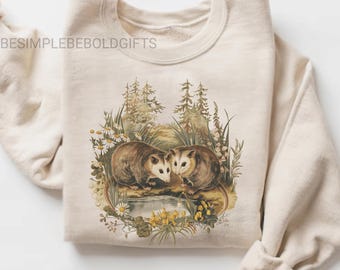 Moletom retrô com estampa de casal de gambás, estilo vintage anos 90, com gola redonda e estampa de flores silvestres, camiseta fofa com animais da floresta, presente aconchegante e boho para amantes da natureza.