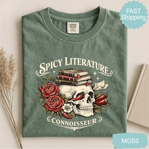 Op de afbeelding: Mosgroen t-shirt met de tekst "Spicy Literature Connoisseur" en een afbeelding van een schedel, boeken, rozen en chilipepers. Het shirt is gemaakt van een zacht, comfortabel materiaal.