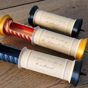 Pode incluir: Três rolhas decorativas para garrafas com detalhes em preto, dourado e azul. Cada rolha tem um corpo cilíndrico com uma citação impressa e uma extremidade cónica. As rolhas estão dispostas sobre uma superfície de madeira.