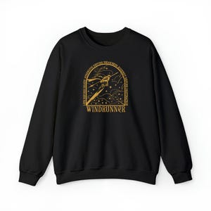 Puede incluir: Sudadera negra con un gr&aacute;fico dorado que presenta una figura estilizada, estrellas y el texto "WINDRUNNER". El dise&ntilde;o est&aacute; enmarcado por las palabras "LIFE BEFORE DEATH, STRENGTH BEFORE WEAKNESS, JOURNEY BEFORE DESTINATION".