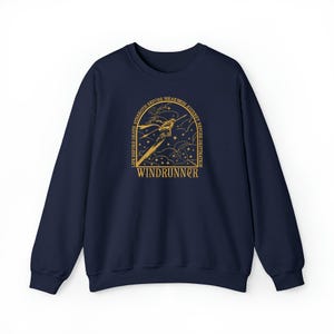 Puede incluir: Una sudadera azul marino con un dise&ntilde;o gr&aacute;fico dorado. El dise&ntilde;o presenta una figura estilizada con la palabra "WINDRUNNER" y el texto "LIFE BEFORE DEATH, STRENGTH BEFORE WEAKNESS, JOURNEY BEFORE DESTINATION".