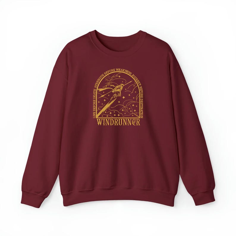 Puede incluir: Una sudadera granate con un dise&ntilde;o gr&aacute;fico dorado. El dise&ntilde;o presenta una ilustraci&oacute;n estilizada con el texto "LIFE BEFORE DEATH, STRENGTH BEFORE WEAKNESS, JOURNEY BEFORE DESTINATION" y la palabra "WINDRUNNER".