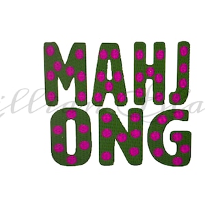 May include: Embroidered text spelling "MAHJONG" in green with pink polka dots. The letters are stitched onto a white background. The word "Lillicake" is written in cursive in the lower left corner.