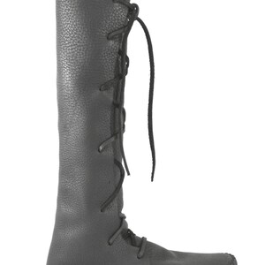 K&ouml;nnte beinhalten: Schwarze, kniehohe Lederstiefel mit Schn&uuml;rung an der Seite und einer Mokassin-Sohle.