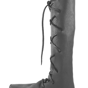 K&ouml;nnte beinhalten: Schwarze, kniehohe Lederstiefel mit Schn&uuml;rung an der Seite. Die Stiefel haben eine Mokassin-Spitze.