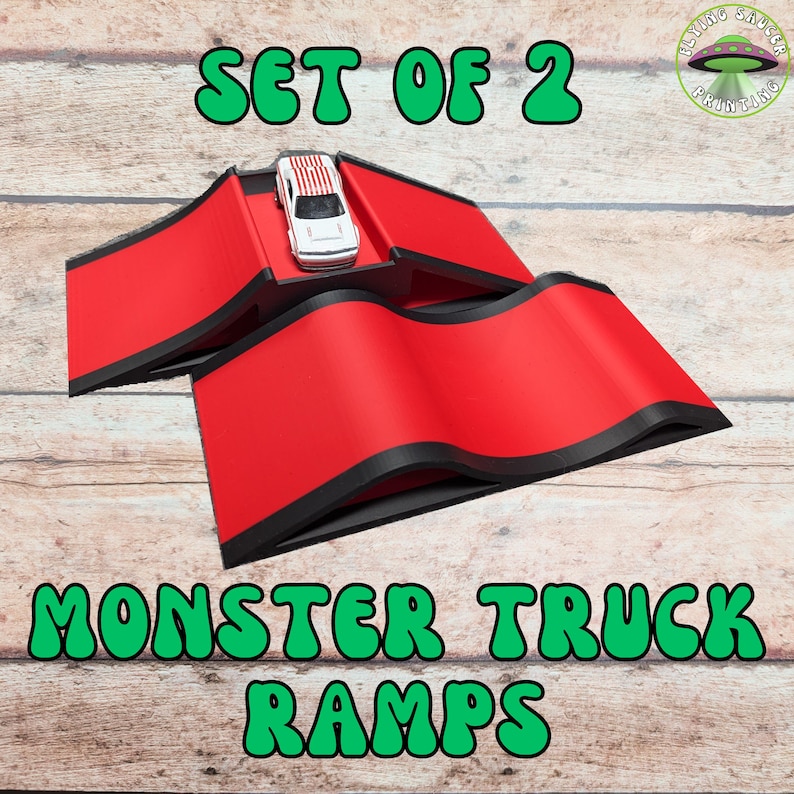 May include: Set of two red monster truck ramps with black trim, and a small toy car with red and white stripes. The ramps are on a wooden surface. Text on the image reads "SET OF 2" and "MONSTER TRUCK RAMPS".