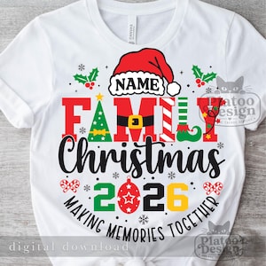 Pu&ograve; includere: Una t-shirt bianca con una grafica che mostra un cappello da Babbo Natale rosso sopra la parola NAME. Il testo FAMILY CHRISTMAS 2026 appare in rosso, nero, verde e giallo con icone natalizie. Il testo recita MAKING MEMORIES TOGETHER.