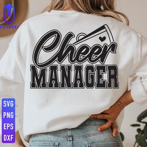 May include: White sweatshirt with the words "Cheer Manager" in black script and block letters. A megaphone graphic with a heart is above the word "Cheer". The sweatshirt is worn by a person in blue jeans.