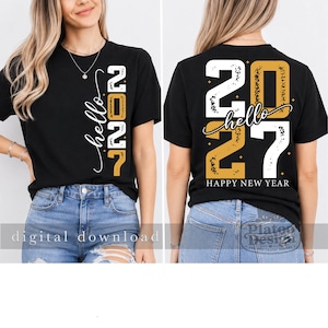 Puede incluir: Una camiseta negra de manga corta con el texto "hello 2027" en blanco y dorado. La parte delantera muestra el texto verticalmente, mientras que la parte trasera presenta un gr&aacute;fico grande con "hello 2027" y "HAPPY NEW YEAR" en fuente desgastada.