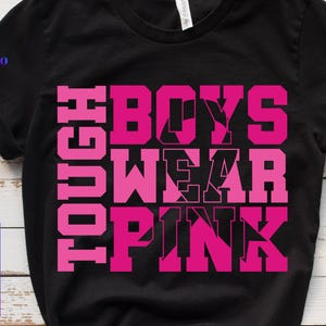 Puede incluir: Camiseta negra con la frase "TOUGH BOYS WEAR PINK" en letras rosas brillantes. La camiseta también tiene el logotipo "PLATOO" en la esquina superior izquierda y las palabras "SVG, PNG, EPS, DXF" apiladas verticalmente.