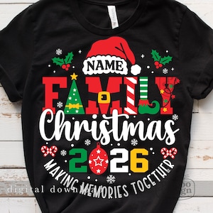 Pu&ograve; includere: Una t-shirt nera con una grafica che mostra un cappello da Babbo Natale rosso sopra la parola NAME, la parola FAMILY in rosso, verde e bianco, la parola Christmas in bianco e il testo MAKING MEMORIES TOGETHER con l'anno 2026 e icone natalizie.