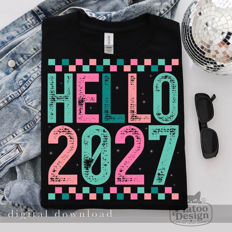 Pu&ograve; includere: Una t-shirt nera con la scritta HELLO 2027 in un carattere usurato e testurizzato con colori alternati turchese e rosa. Il design include un bordo a scacchi nella parte superiore e inferiore e piccoli accenti a stella nelle lettere.
