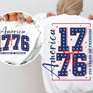 Puede incluir: Sudadera blanca con el texto "America 1776" en azul marino con estrellas blancas, celebrando 250 a&ntilde;os de libertad. El dise&ntilde;o se repite en la espalda. Tema patri&oacute;tico.