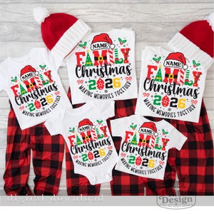 Pu&ograve; includere: Una collezione di magliette bianche e un body per neonati con una stampa grafica con il testo NAME, FAMILY, Christmas, 2026 e MAKING MEMORIES TOGETHER, accompagnati da due berretti in maglia rossi e bianchi e pantaloni a quadri rossi e neri.