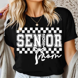 May include: A white ceramic mug with a black handle and the text "But First, Coffee" in a black, handwritten-style font. The mug is on a white surface.