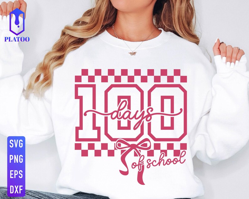May include: White sweatshirt with a pink graphic that reads "100 days of school." The design includes the number 100 in a bold font, with the words "days" and "of school" in a script font. The design is surrounded by a checkered pattern.