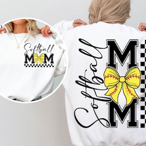 May include: White sweatshirt with the text "Softball Mom" in black script and block letters. A yellow softball bow is centered on the front and back. The back features the word "Softball" in script and a black and white checkered pattern.