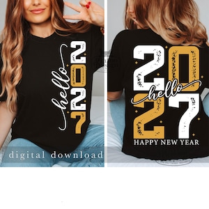 Puede incluir: Una camiseta negra con un dise&ntilde;o gr&aacute;fico que incluye el texto hello 2027 en colores blanco y dorado. El dise&ntilde;o presenta peque&ntilde;os detalles de estrellas y una textura desgastada en los n&uacute;meros. La parte trasera muestra el texto HAPPY NEW YEAR.