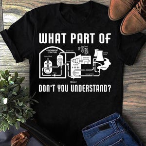 May include: Black t-shirt featuring a white diagram of a power plant with the text "WHAT PART OF DON'T YOU UNDERSTAND?" The diagram includes labels such as "Reactor" and "Turbines."