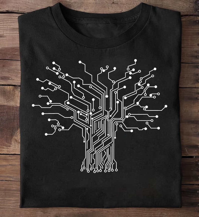 May include: Black t-shirt featuring a white circuit board design in the shape of a tree. The graphic has a detailed, technical appearance, with lines and circles representing electronic components. The shirt is made of a soft material.