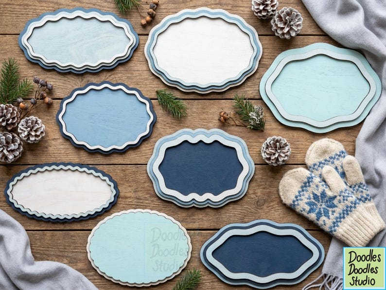 Peut inclure: Une collection de huit plaques en bois aux bords festonn&eacute;s dans diverses nuances de bleu, blanc et bleu sarcelle clair. Les plaques pr&eacute;sentent des designs superpos&eacute;s avec des finitions lisses, dispos&eacute;es avec des pommes de pin et des moufles.
