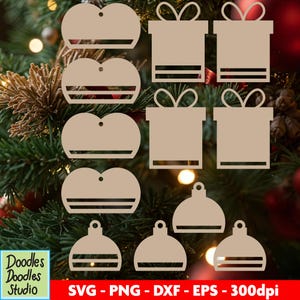May include: A collection of laser-cut wooden Christmas ornaments in various shapes, including gift boxes, heart-shaped tags, and bulb ornaments. The ornaments are a light brown color and are displayed against a backdrop of a Christmas tree. The image also includes the text "Doodles Doodles Studio" and file type information.