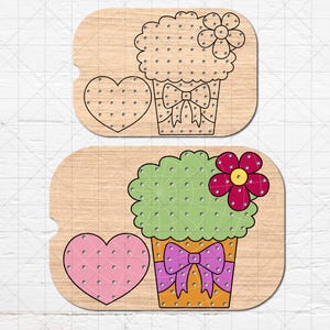 May include: Two wooden pegboard designs. One features a cupcake with a flower and bow, and a heart. The other has a green cupcake with a pink flower and bow, and a pink heart. The designs are on a light wood background.