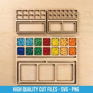 Könnte beinhalten: Ein helles Holz-Organizer-Tablett mit mehreren quadratischen Fächern, die mit kleinen, bunten Perlen in Blau, Grün, Rot, Gelb und Orange gefüllt sind, sowie leeren rechteckigen Abschnitten und zwei zusätzlichen leeren Holztabletts.