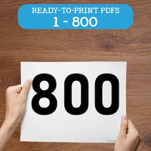 Pode incluir: Uma folha de papel branca com o número 800 em negrito preto, sobre um fundo de madeira. O texto "READY-TO-PRINT PDFs 1-800" está num retângulo azul no topo. O logotipo Doodles Doodles Studio está no canto inferior esquerdo.