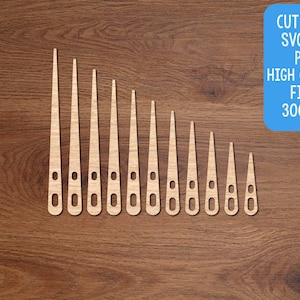 May include: Eleven wooden, elongated shapes with a pointed top and a rounded bottom with a hole, arranged diagonally on a brown wooden surface. Text in a blue box reads "CUT FILES SVG, DXF, PNG HIGH QUALITY FILES 300 DPI."