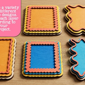 Peut inclure: Une collection de cadres en bois superpos&eacute;s de formes carr&eacute;es et ondul&eacute;es. Les cadres pr&eacute;sentent des bords festonn&eacute;s et sont peints en orange, jaune, bleu et corail. Le texte sur l'image indique : Create a variety of different frame designs. Color each layer according to your project. Doodles Doodles Studio.