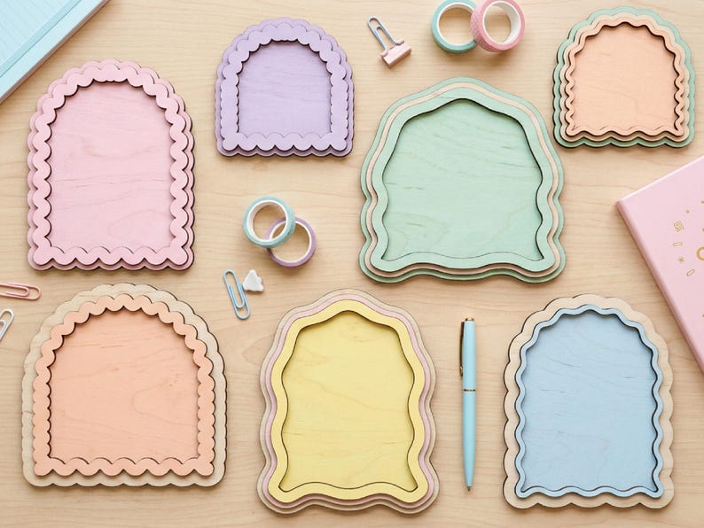 Peut inclure: Un ensemble de six plaques en bois en forme d'arche avec des bords festonn&eacute;s dans des tons pastel incluant rose, lavande, vert, p&ecirc;che, jaune et bleu, dispos&eacute;es avec de la papeterie comme du ruban adh&eacute;sif, des trombones et un stylo.