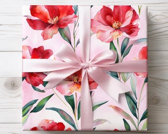 May include: A pink gift box with a pink satin ribbon bow. The box is wrapped in floral patterned paper with red and pink flowers and green leaves.