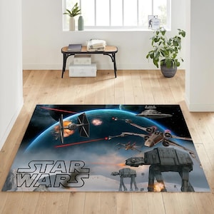 May include: Rectangular Star Wars area rug featuring a space battle scene with X-wings, TIE fighters, and AT-AT walkers. The rug has a blue planet and the Star Wars logo.